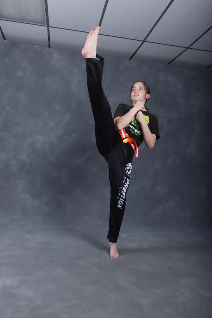 girl throwing a front kick, teen martial arts