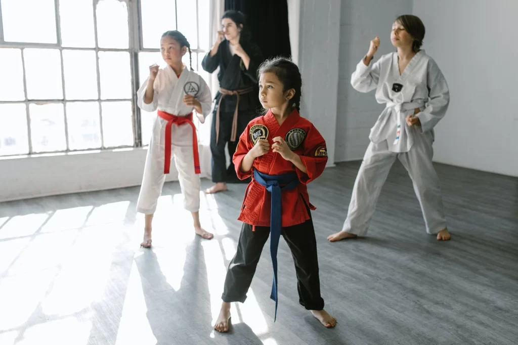 a young girl in karate class with 2 other students