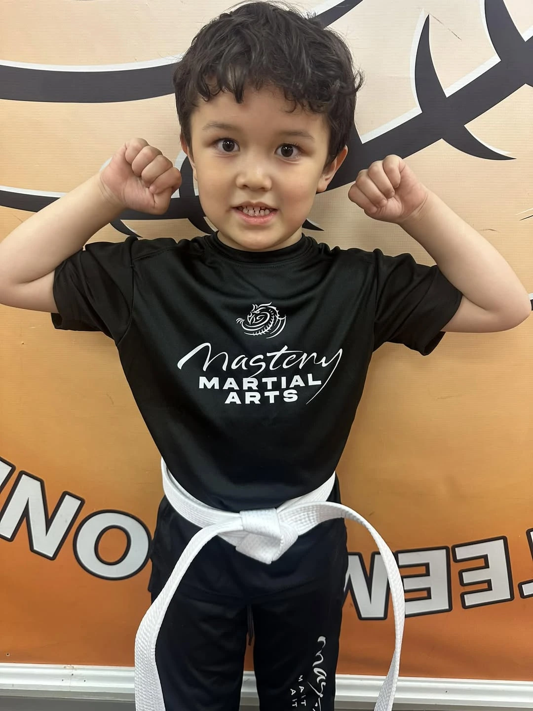 Young karate boy making muscles Young karate boy making muscles