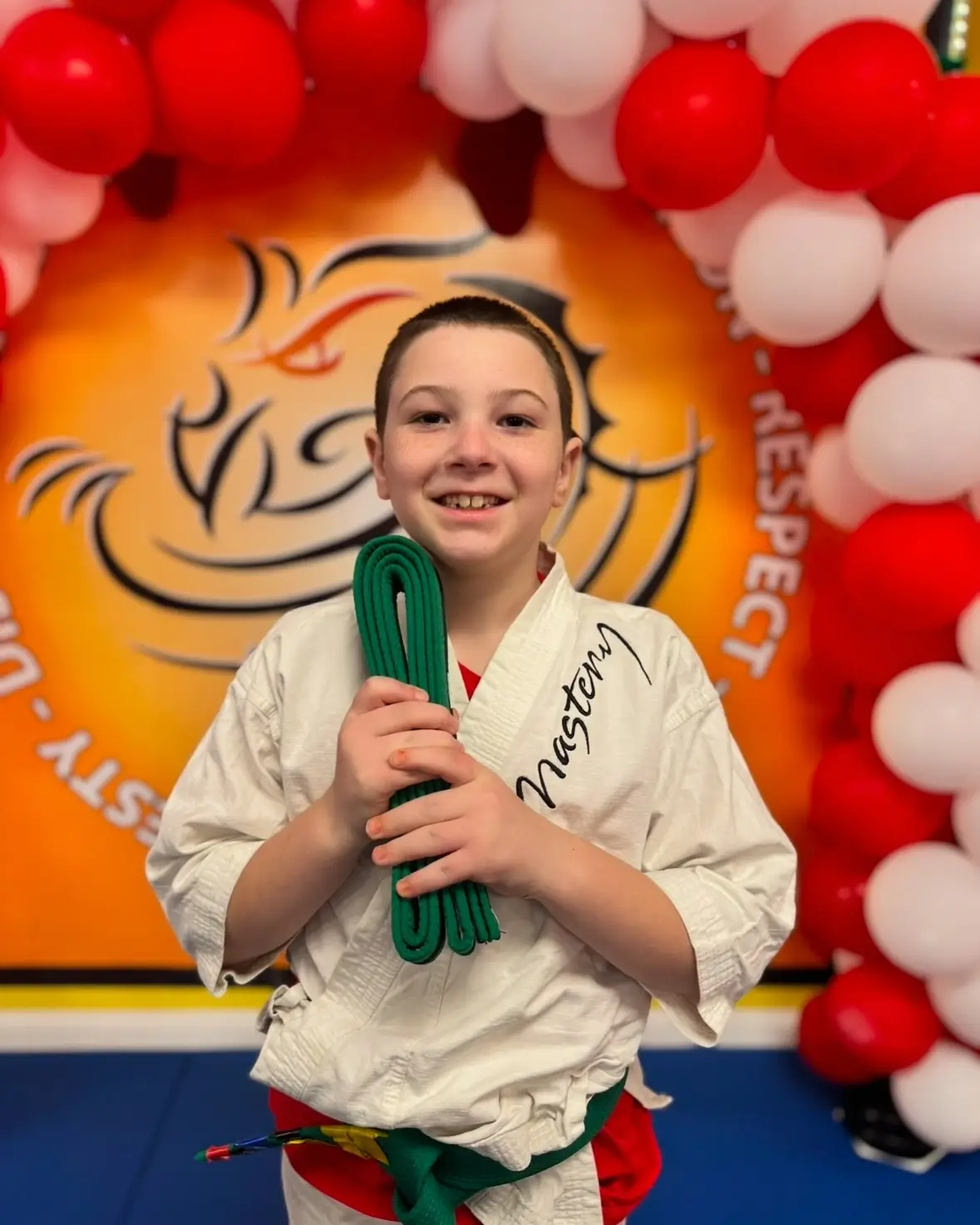 boy at karate holding new Green Belt boy at karate holding new Green Belt