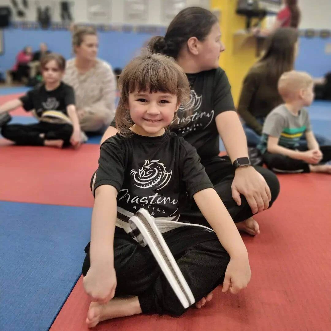 smiling karate gril sitting at karate class