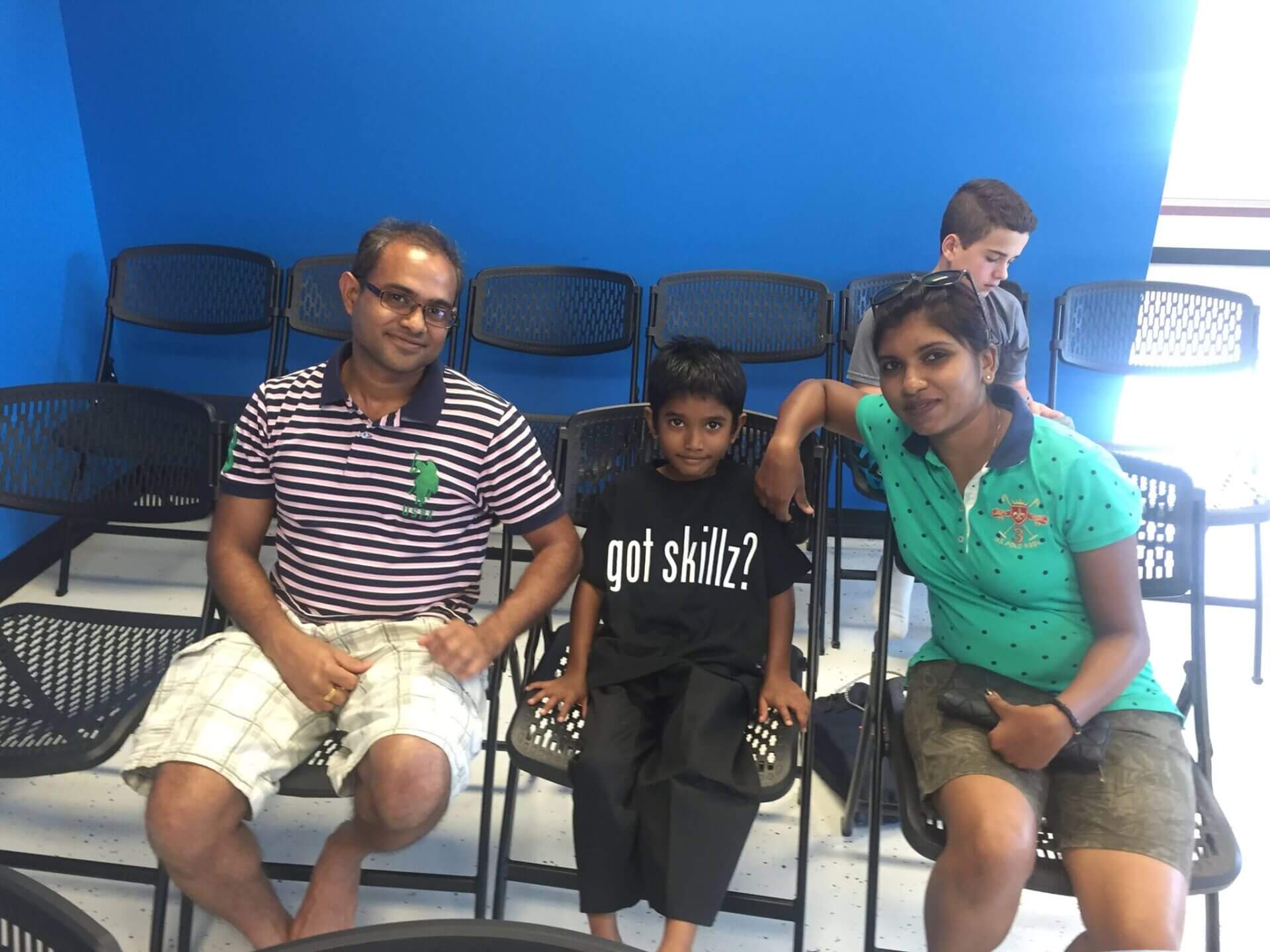 young boy sitting with parents at martial arts class.